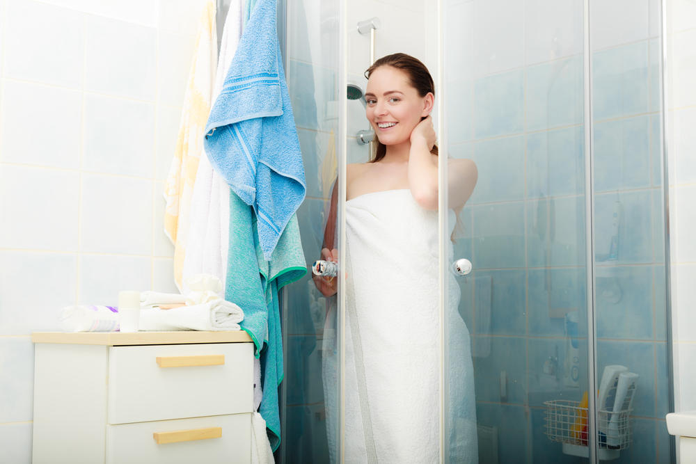 Жена после душа обматывает себя полотенцем фото