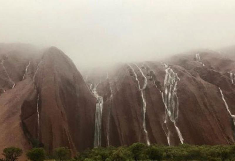 В Австралии ливни превратили священную скалу в водопад