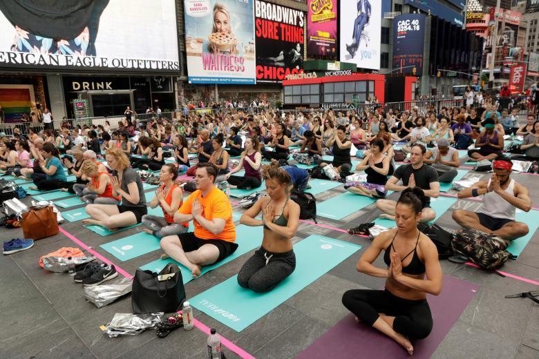 Массовый сеанс йоги на Таймс-сквер в Нью-Йорке