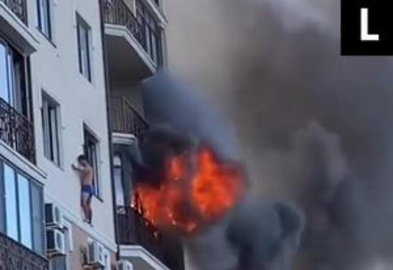 Россиянин вылез на карниз дома из-за пожара и попал на видео
