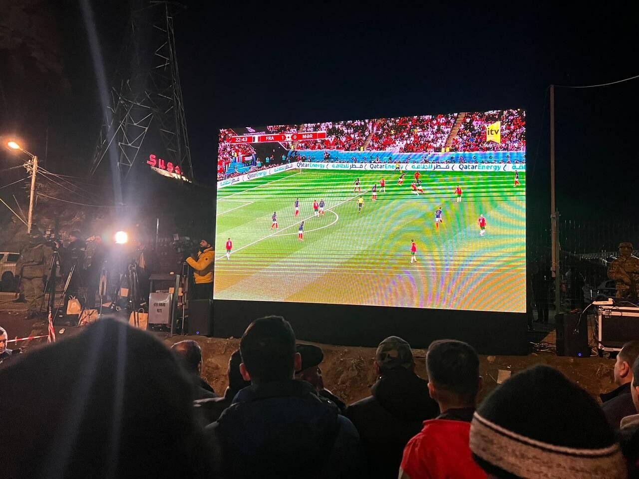 Участники акции протеста и миротворцы вместе смотрят футбольный матч Франция-Марокко