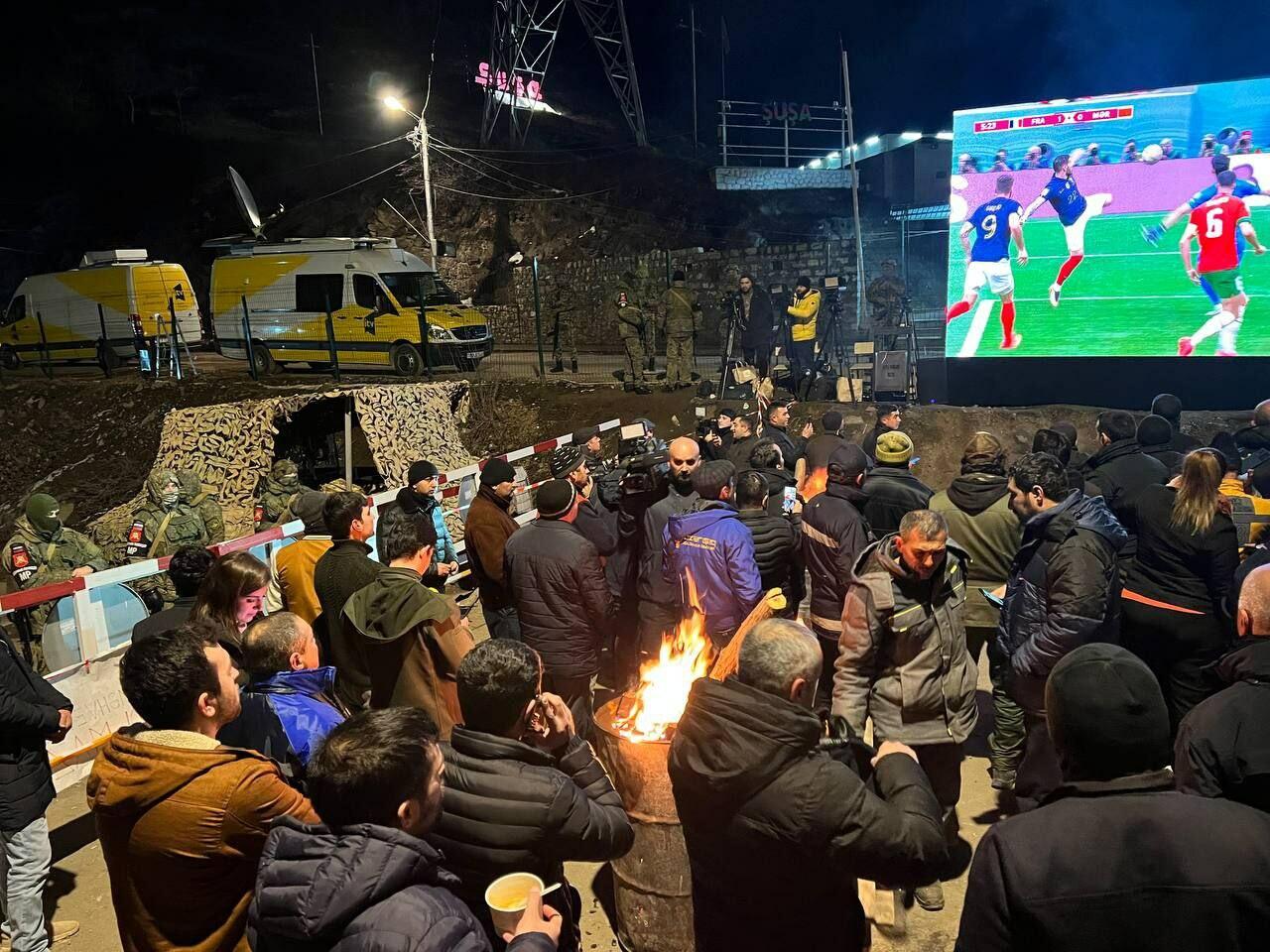 Участники акции протеста и миротворцы вместе смотрят футбольный матч Франция-Марокко