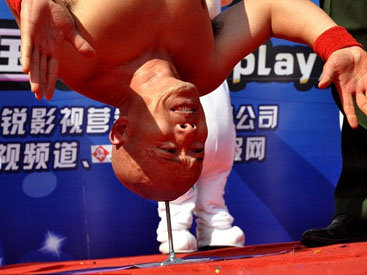 Китаец научился стоять вниз головой на гвозде - ФОТО