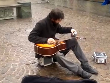 Уличный музыкант играет на гитаре с помощью фляги - ВИДЕО