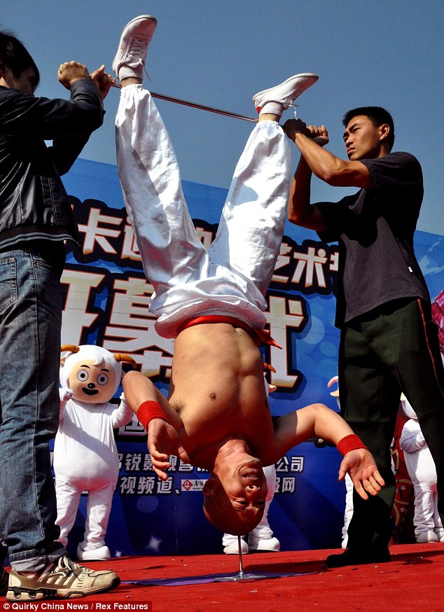 Китаец научился стоять вниз головой на гвозде - ФОТО